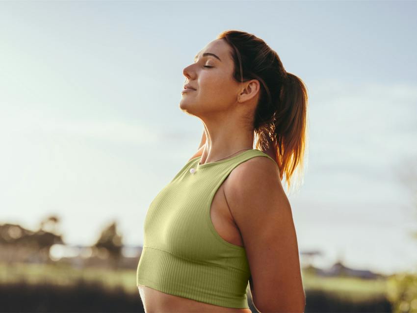 woman outside with eyes closed looking up