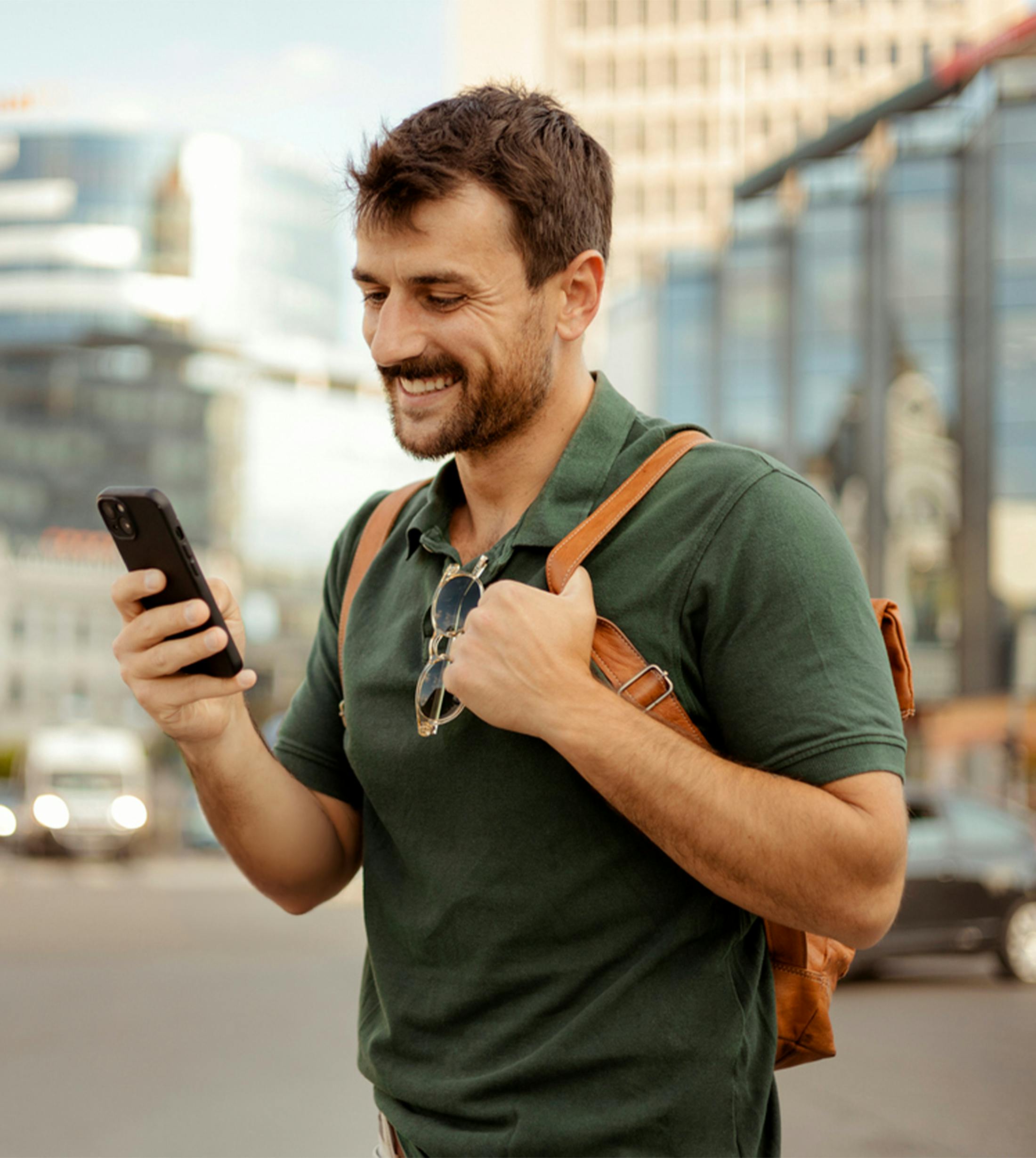 man with backpack smiling at phone