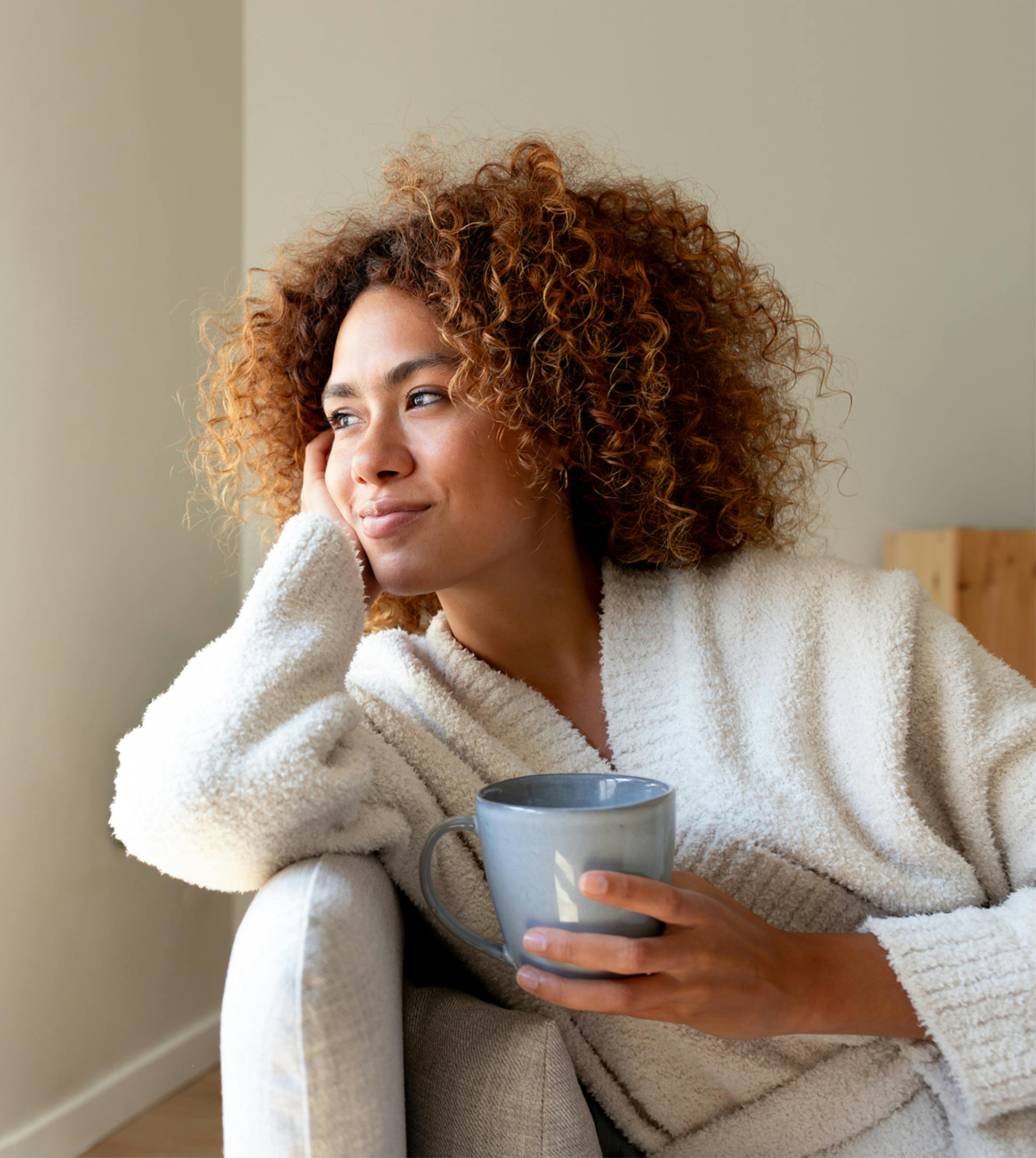 woman leaning in chair holding mug