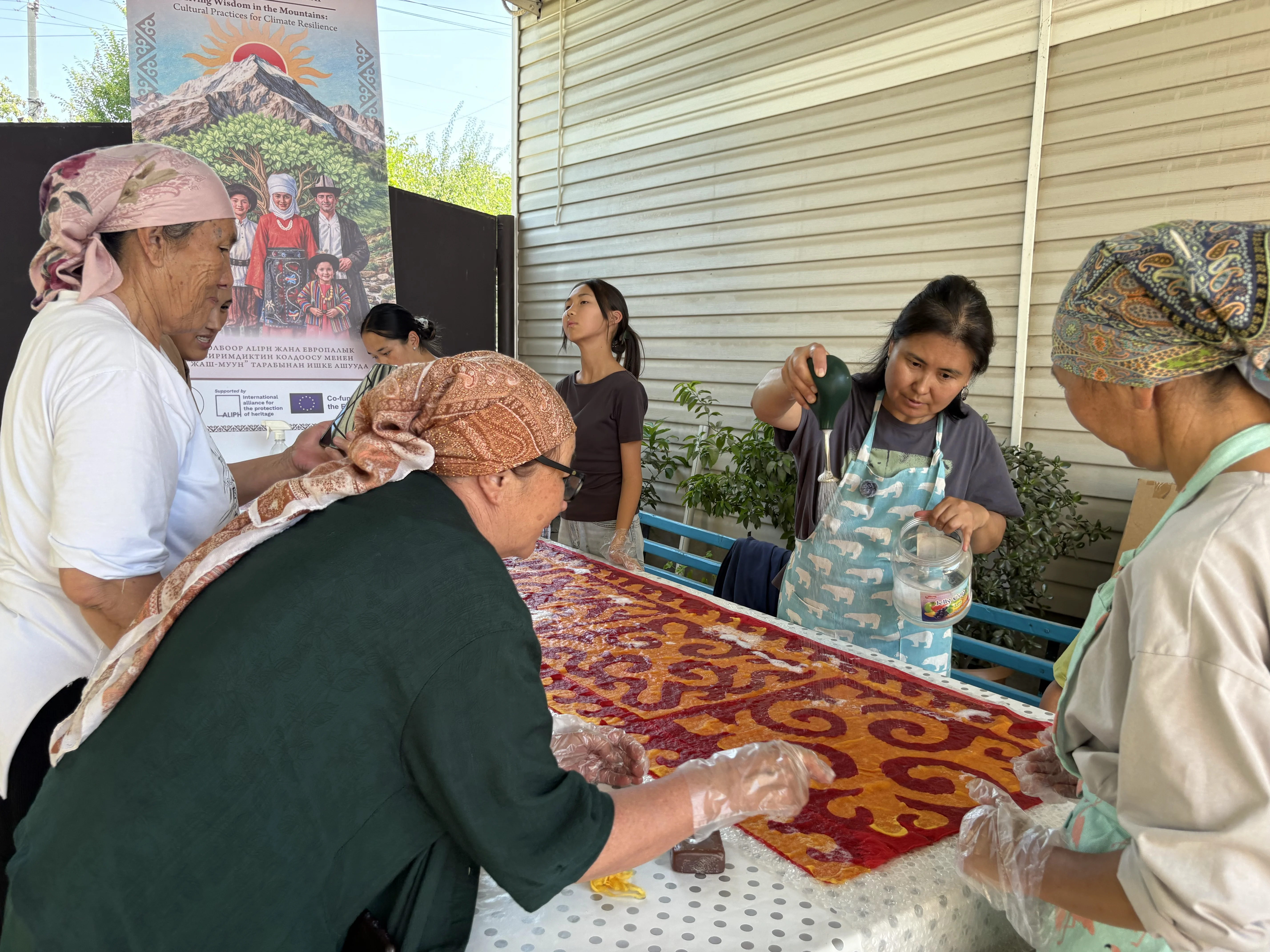 Craftswomen wetting the laid-out pattern on the worktable