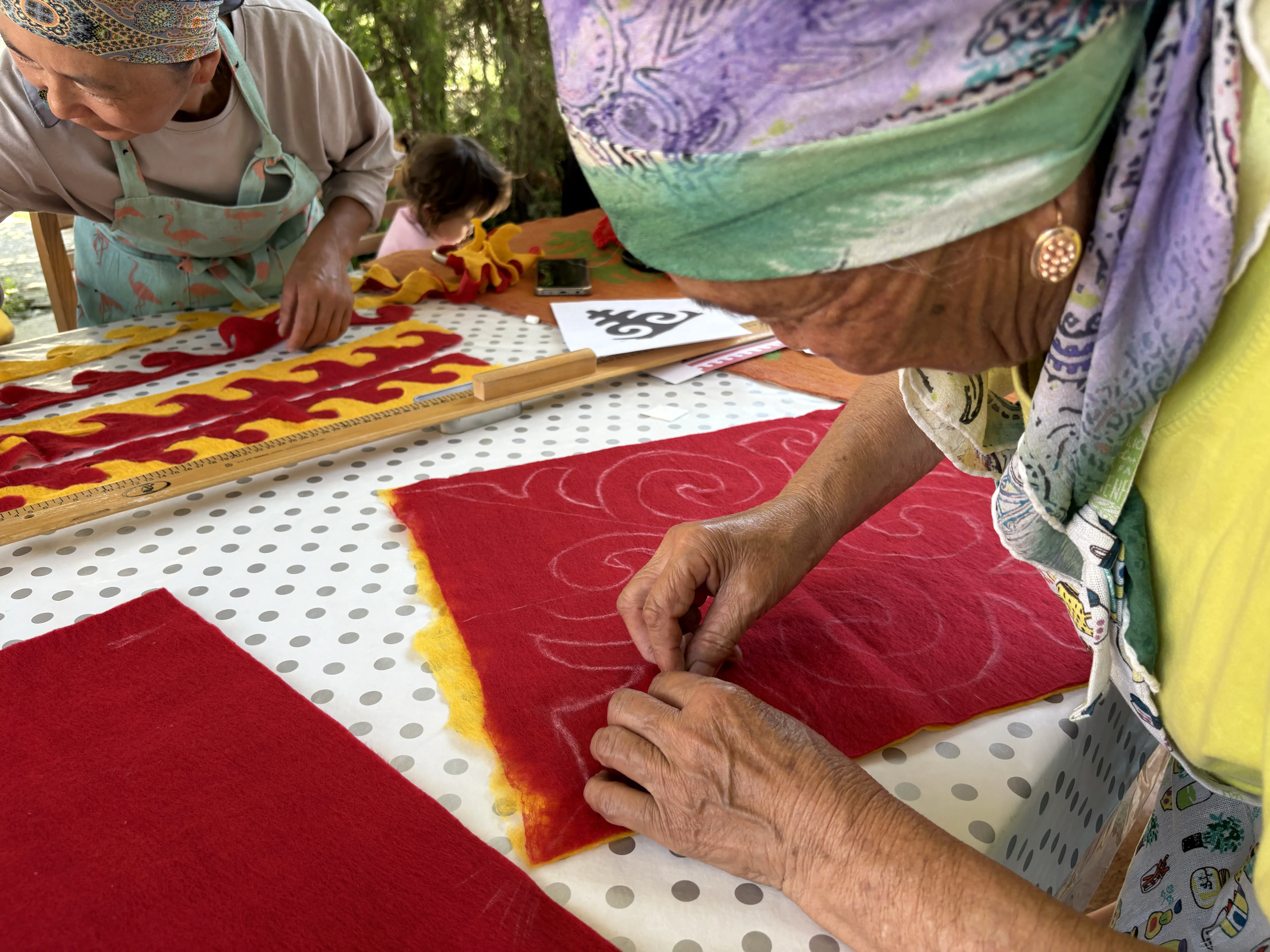 A craftswoman cutting the ornament out of red prefelt