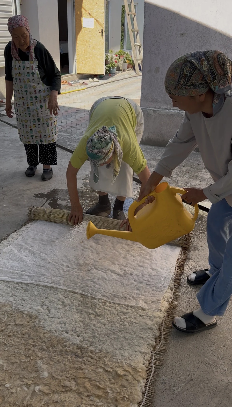 Полив разложенной шерсти горячей водой из лейки