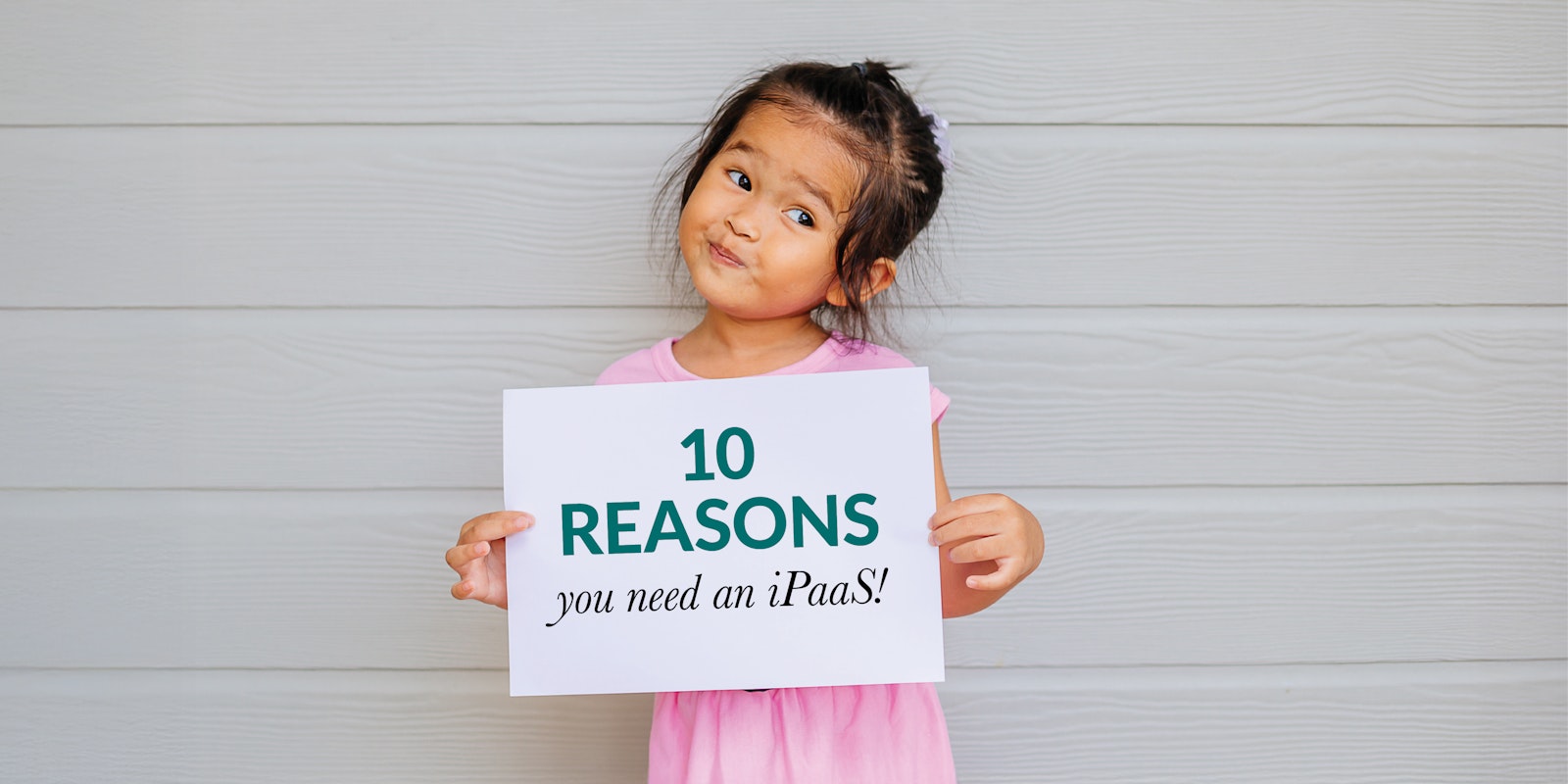 Person holding a poster displaying “10 Reasons You Need an iPaaS” representing the benefits of integration platforms for connecting business systems and improving technology stack efficiency.