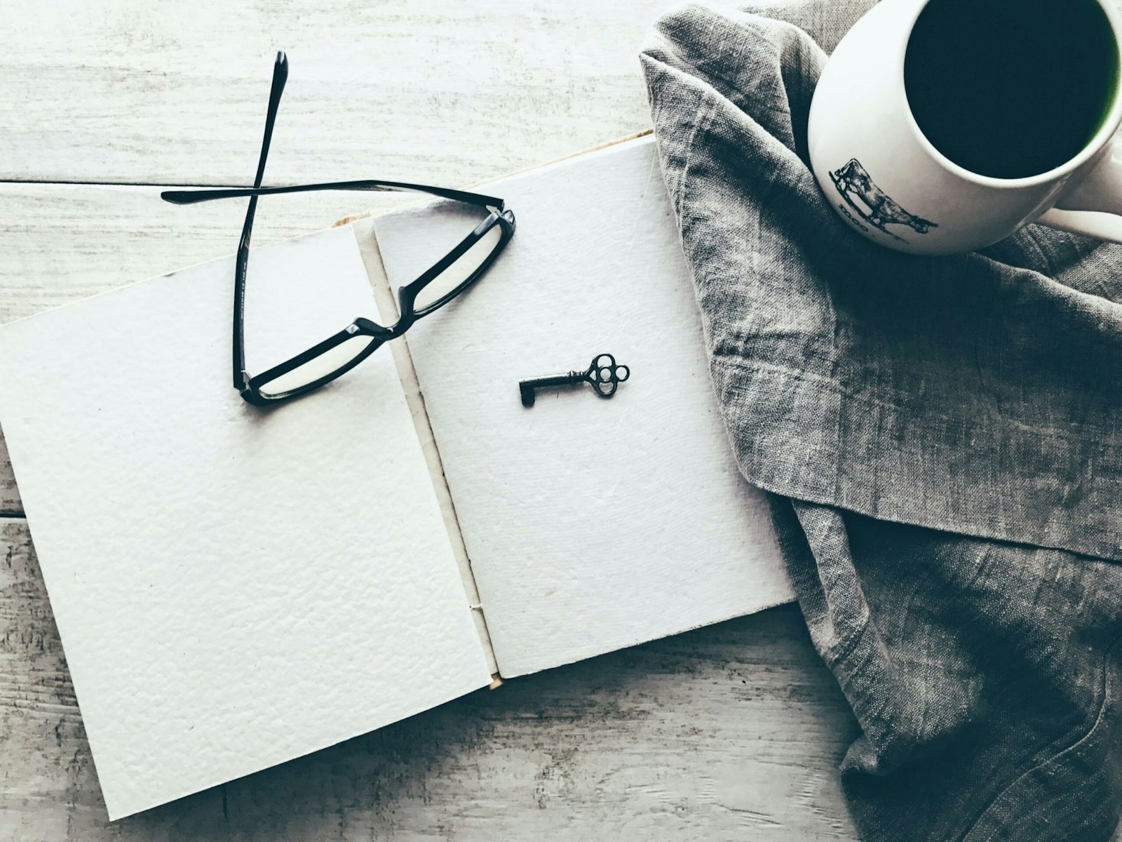 Graphic showing an open black notebook with glasses and a key, symbolizing education, discovery, and understanding application programming interfaces.