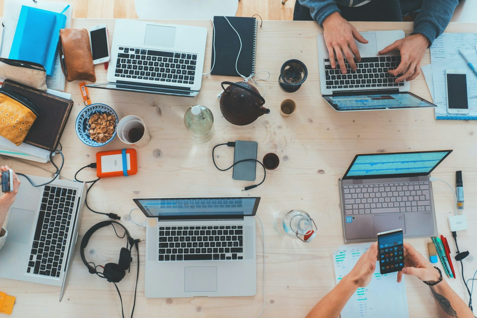 Overhead view of a modern workspace with laptops, headphones, and office equipment, representing enterprise resource planning (ERP) integration and connected business operations.