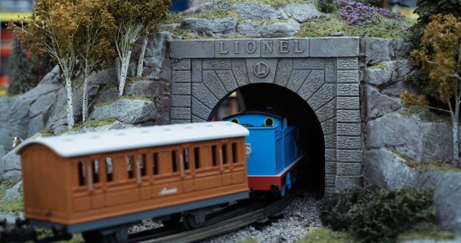 Model Lionel train traveling through a tunnel with a Lionel sign above, illustrating the Lionel Trains integration case study.