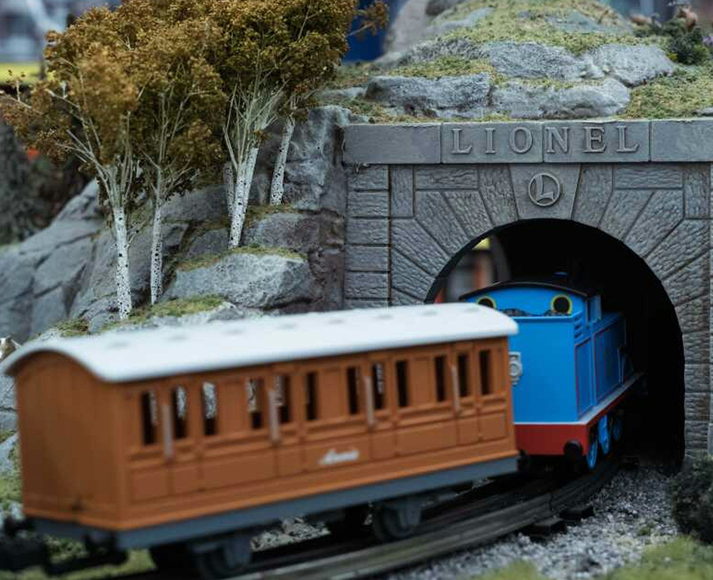 Model Lionel train traveling through a tunnel with a Lionel sign above, illustrating the Lionel Trains integration case study.