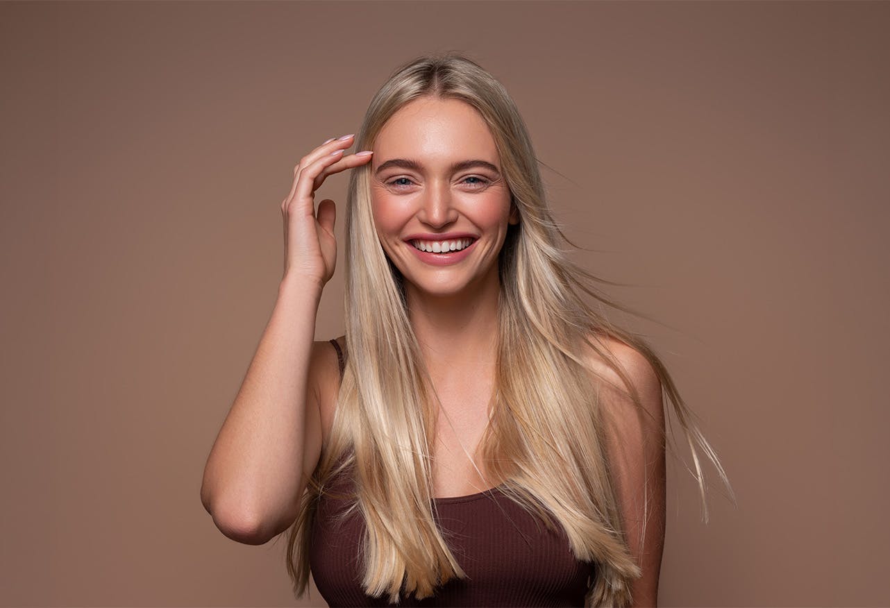 women smiling touching hair