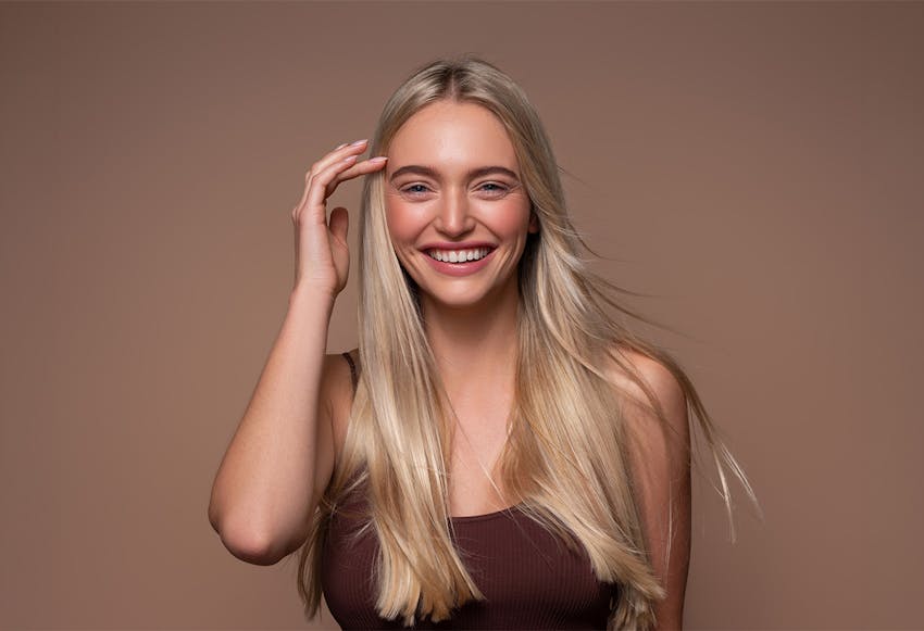 women smiling touching hair