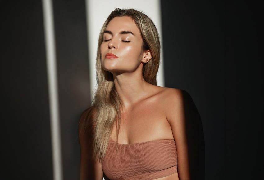 women in sunlight closing eyes