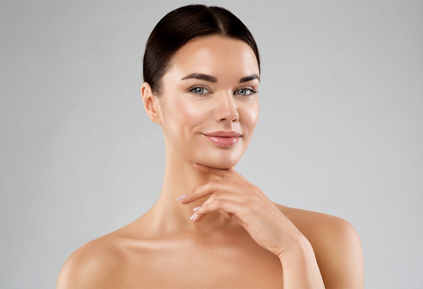 woman smirking with her hand under chin