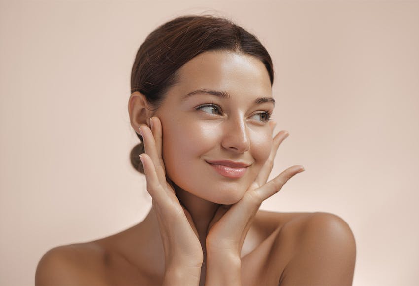women smirking with hands on face