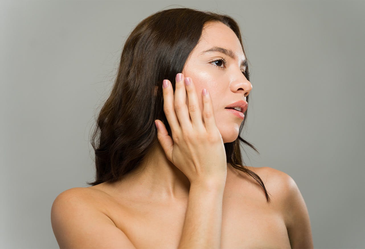 woman touching her cheek