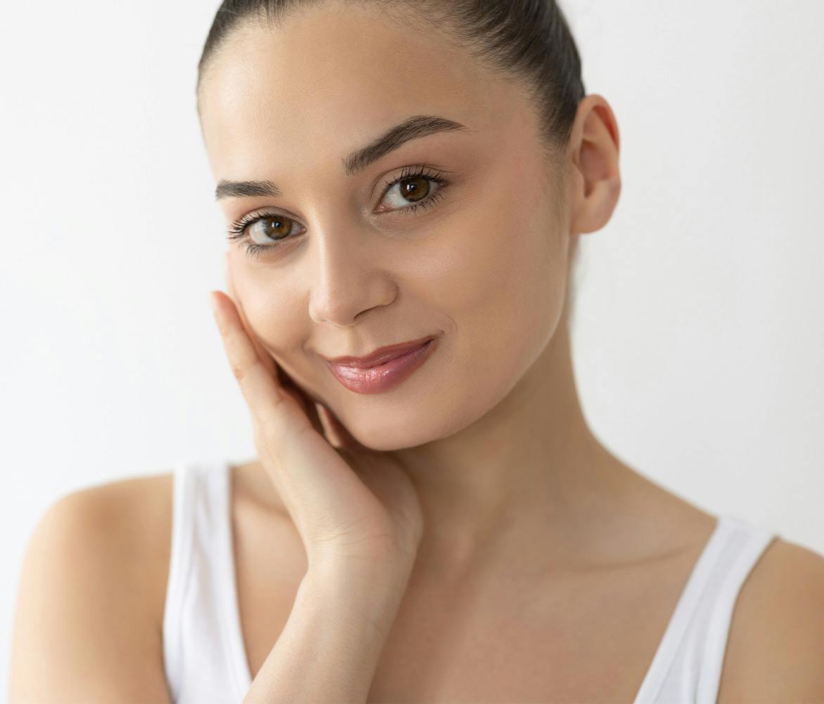 woman smirking with hand on cheek