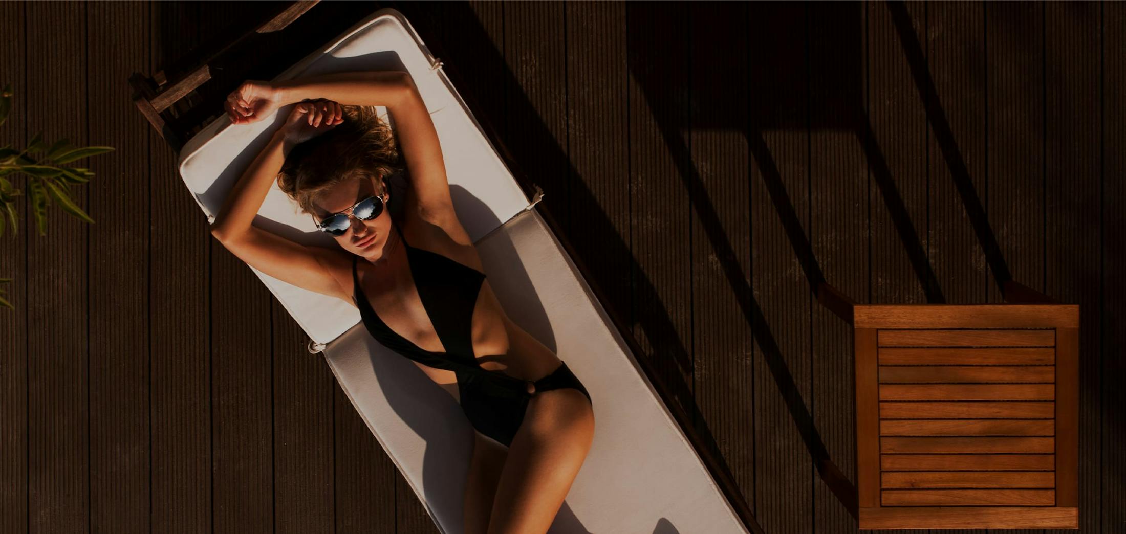 Woman lounging on a pool chair in a bathing suit