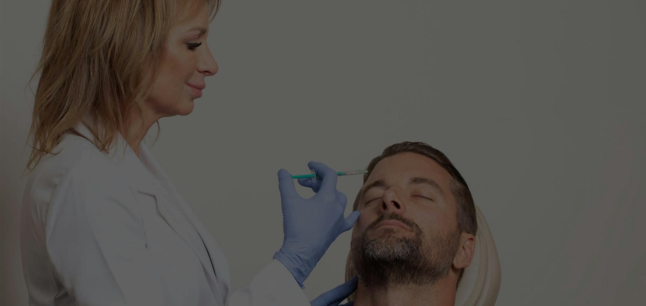 Male patient receiving facial filler injections to his forehead
