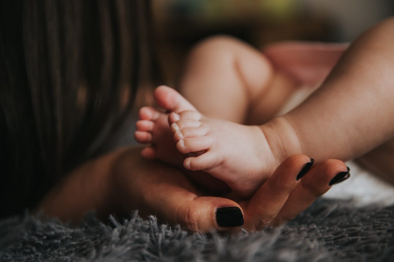mother holding a baby foot