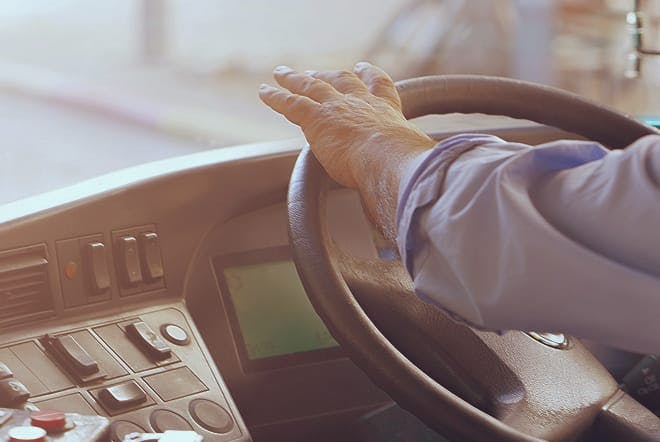 someone's hand on a steering wheel