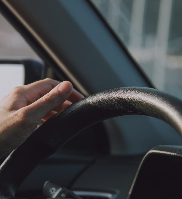 person's hand on a steering wheel
