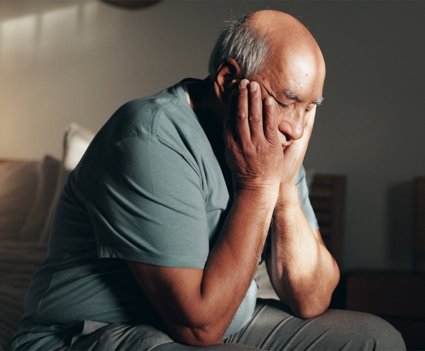Older man holding his face