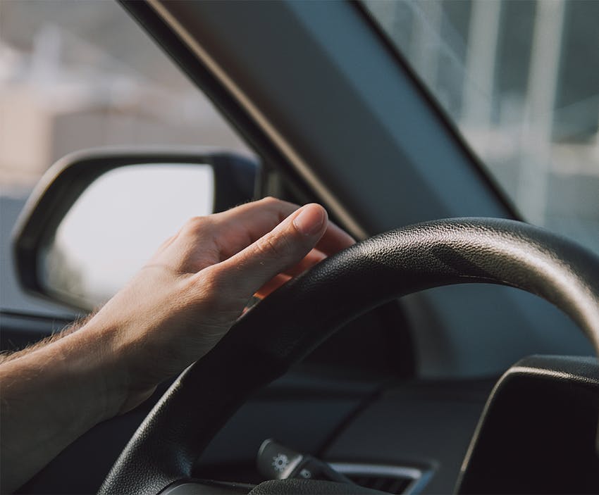 A hand on a steering wheel