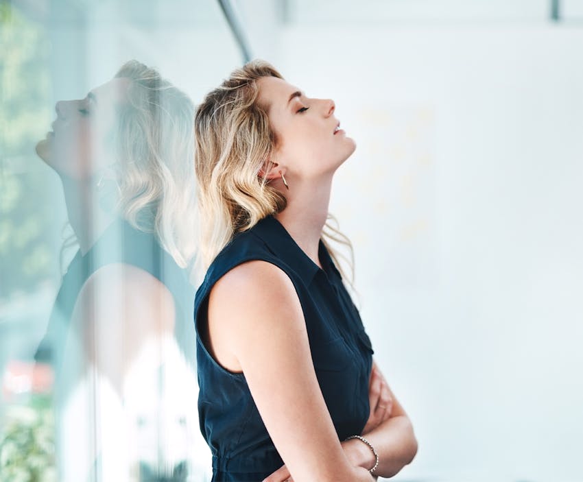 woman leaning against a glass wall