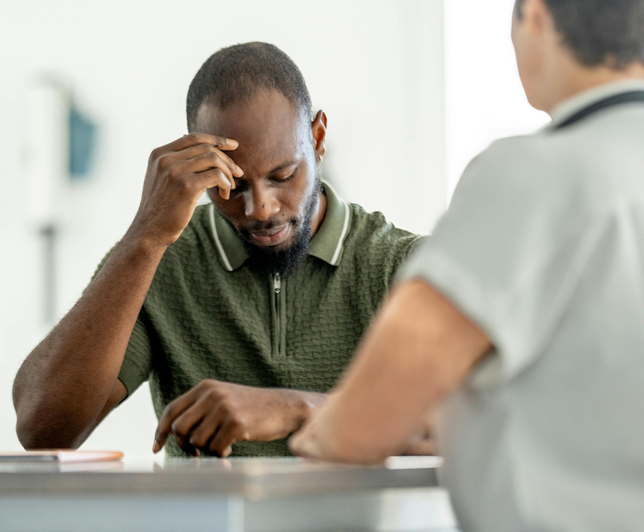man leaning his head on his hand