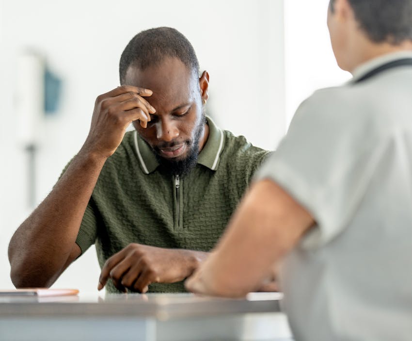 man leaning his head on his hand