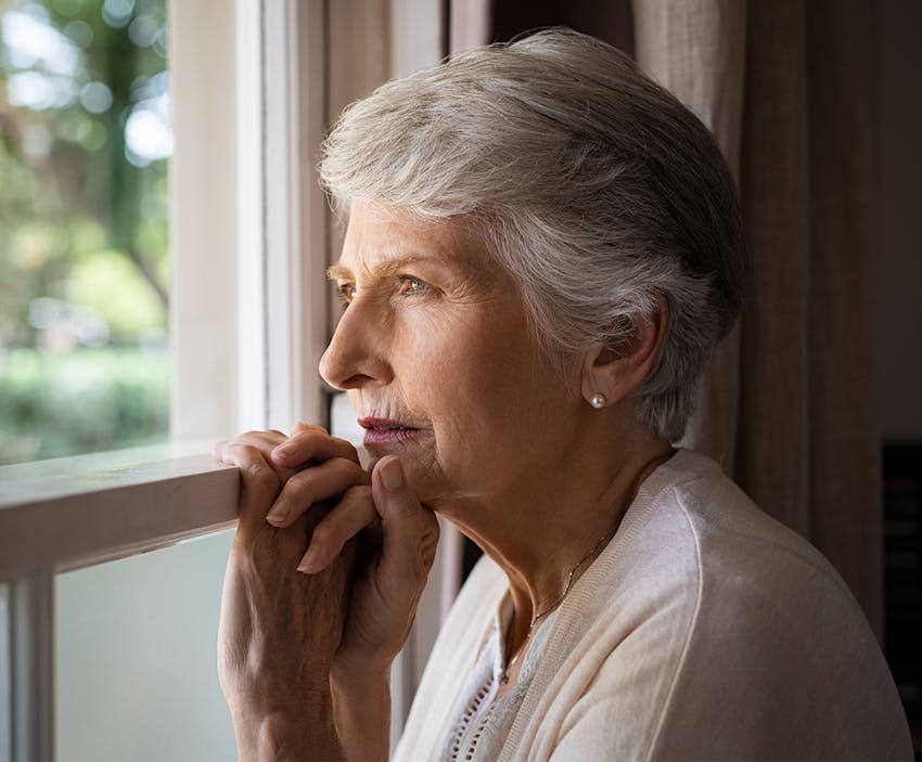 Older woman looking out a window