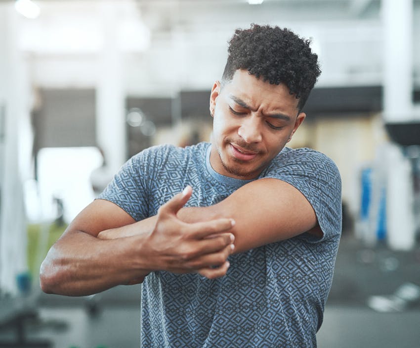 man holding his elbow in pain
