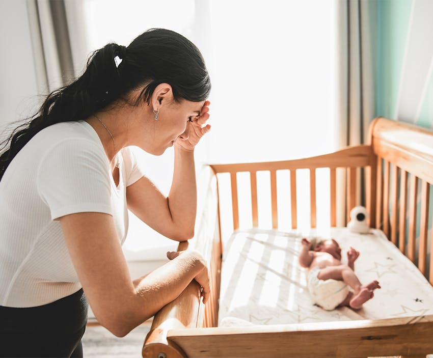 woman looking at her crying baby