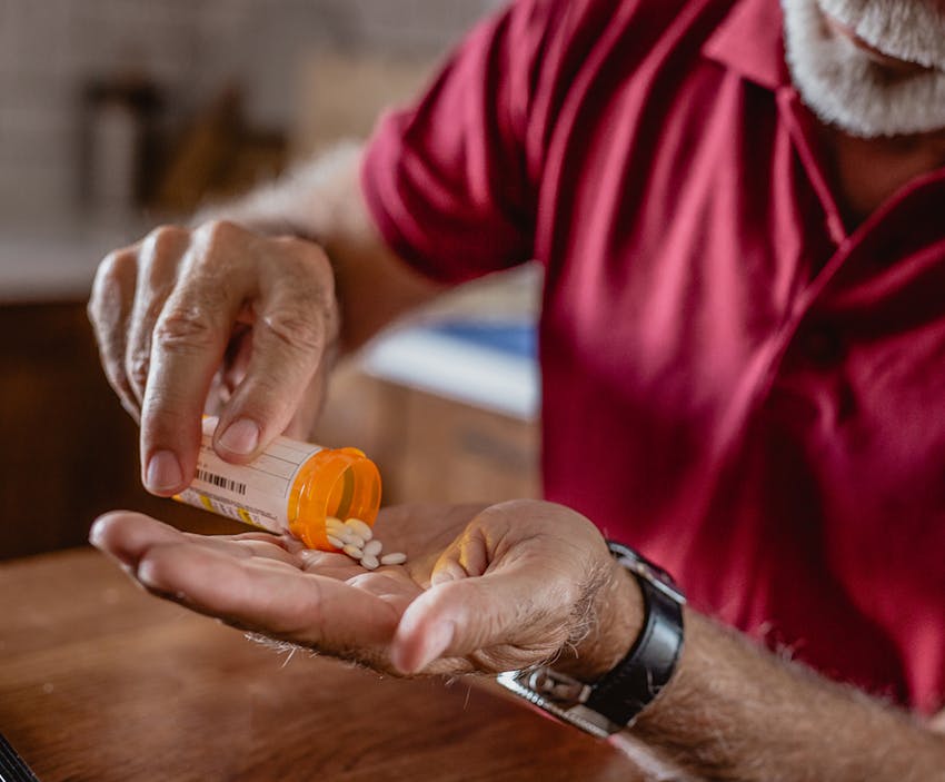 man pouring pills into his hand