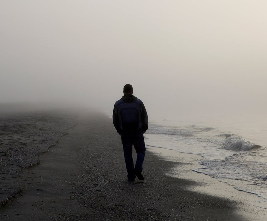 man walking on a misty beach