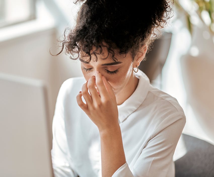 woman pinching the bridge of her nose