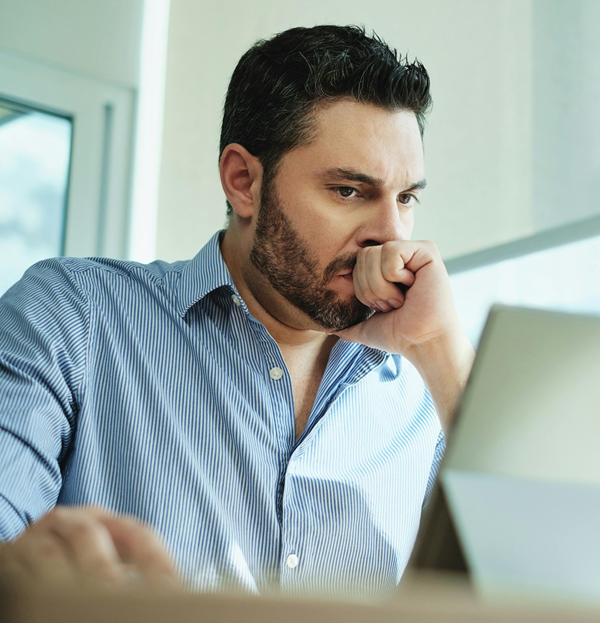 stressed man looking at a tablet