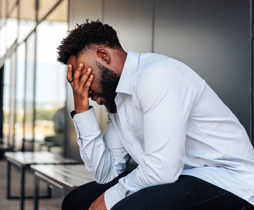 man covering his eyes