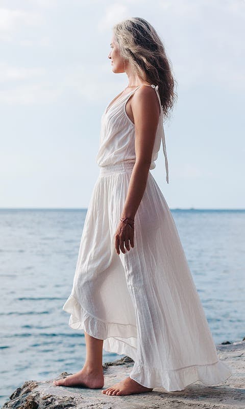 woman in white dress by beach