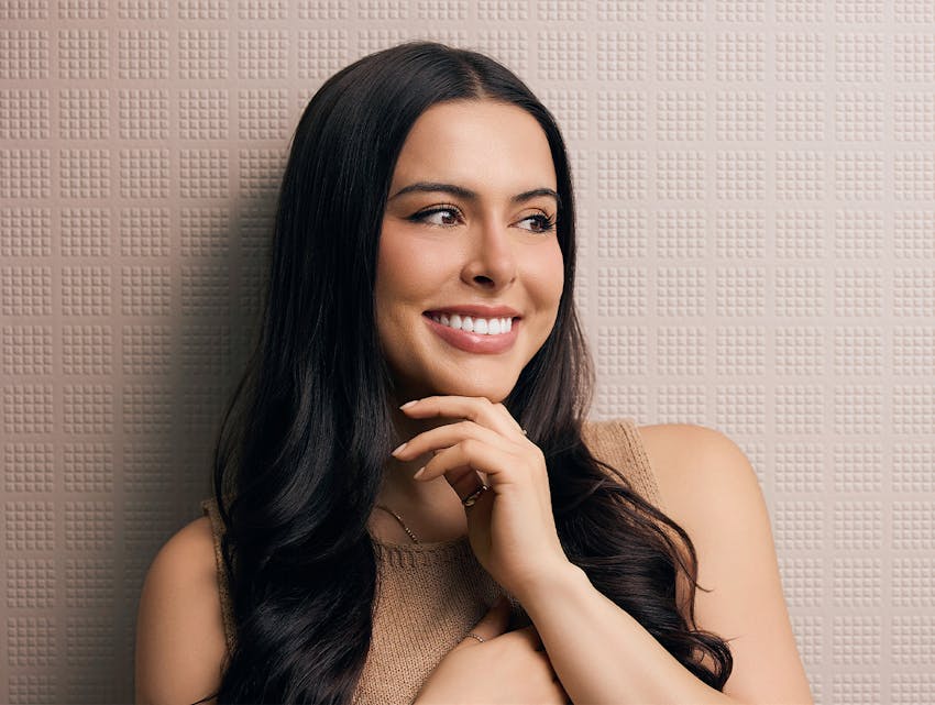 woman smiling, touching her chin