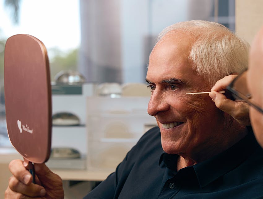 doctor showing a patient his results in a hand mirror
