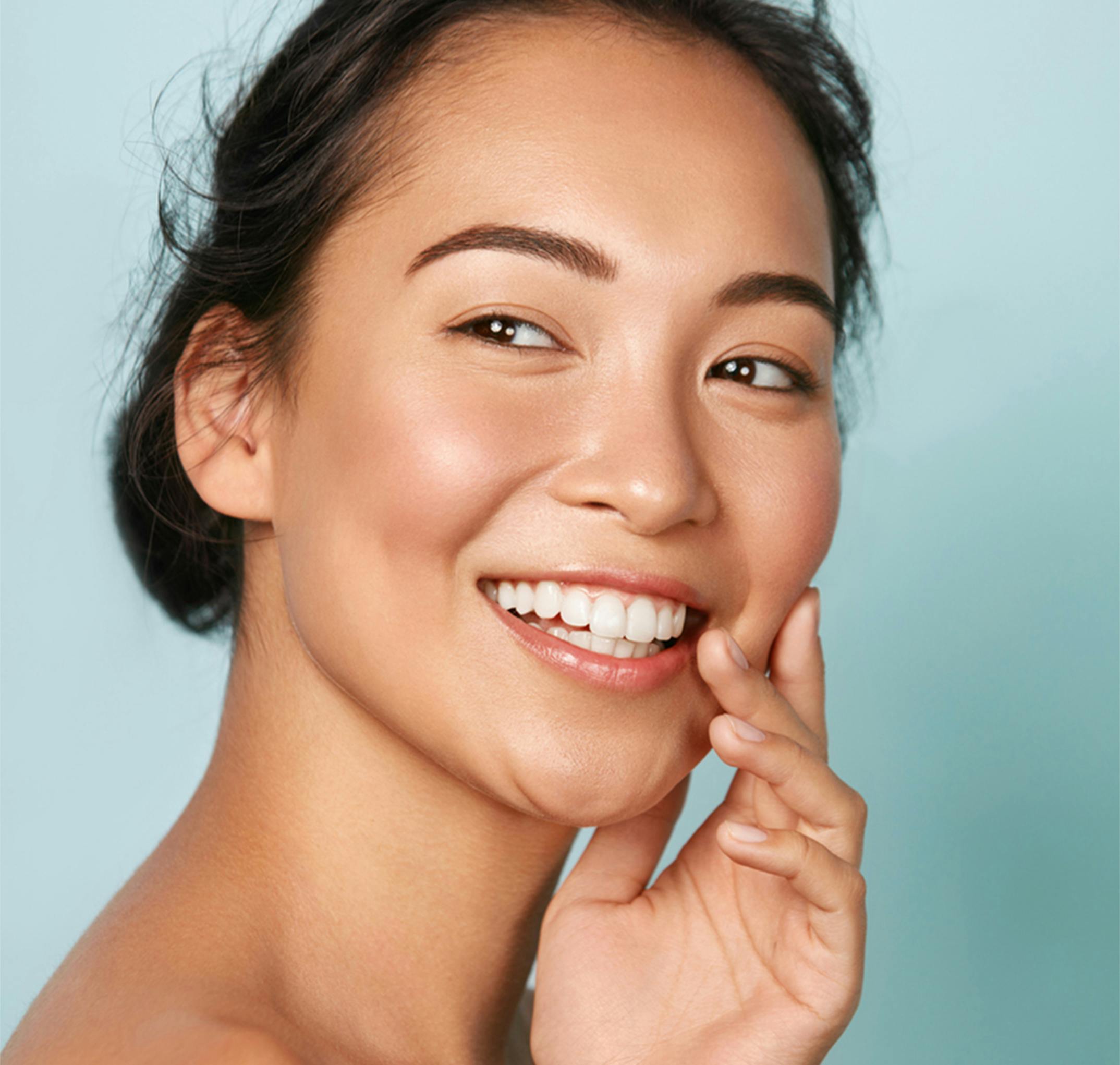 smilign woman touching her face