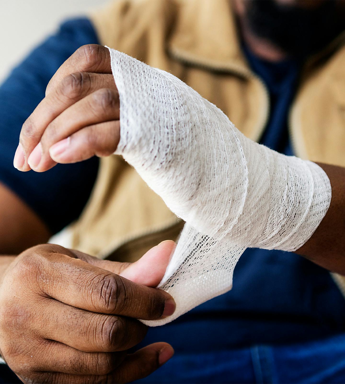 man wrapping his hand in gauze
