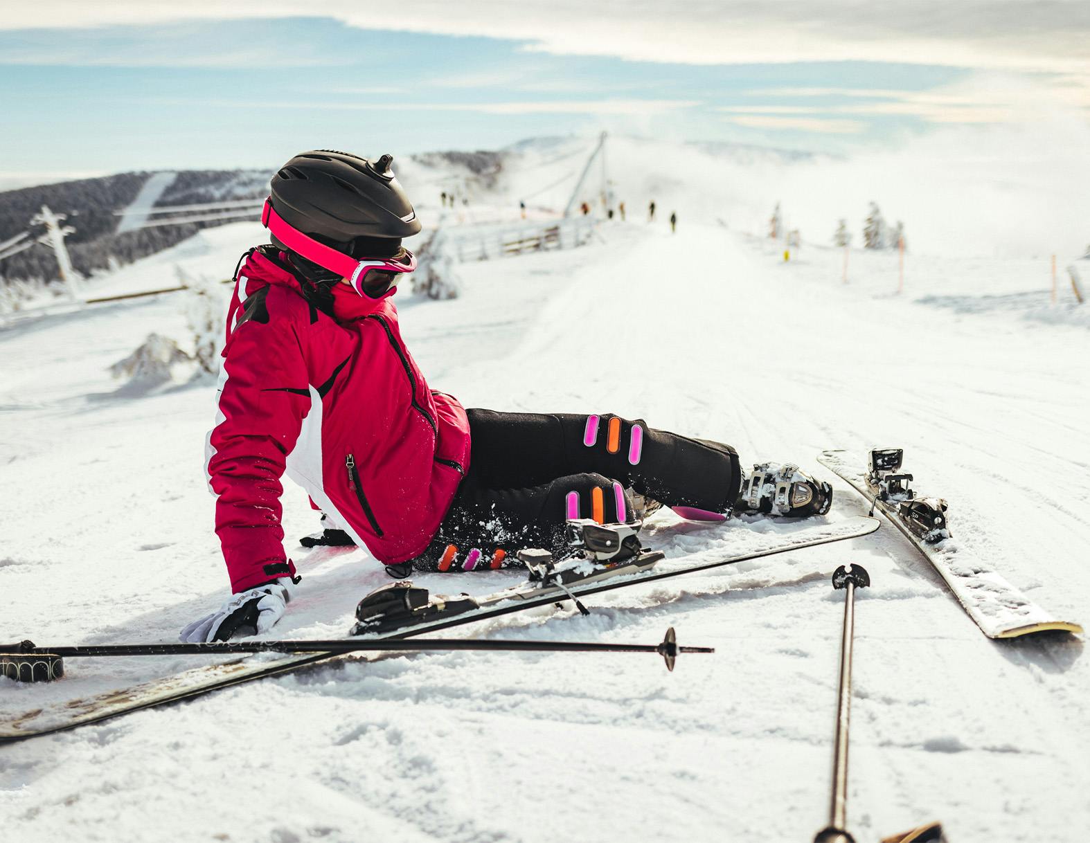person laying on the ground next to their skis