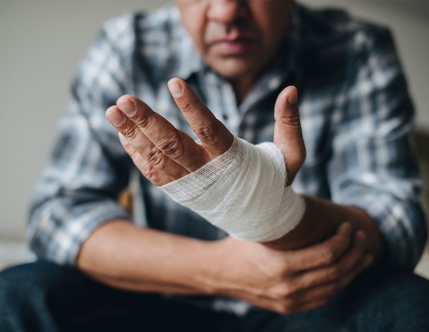 man holding his hand that is wrapped in gauze