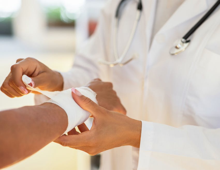 doctor wrapping a patient's wrist in gauze