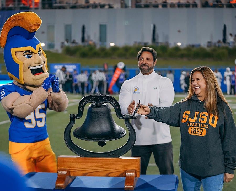 Habbas claping as a woman rings a bell at a football game