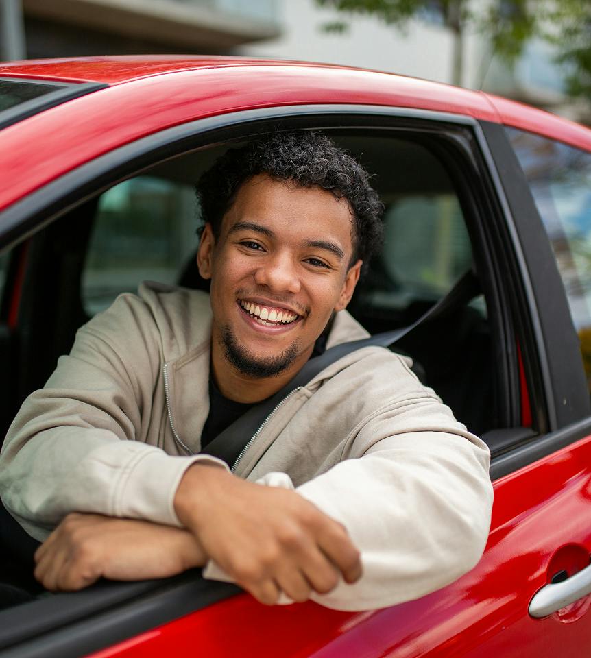 man smiling out the car window