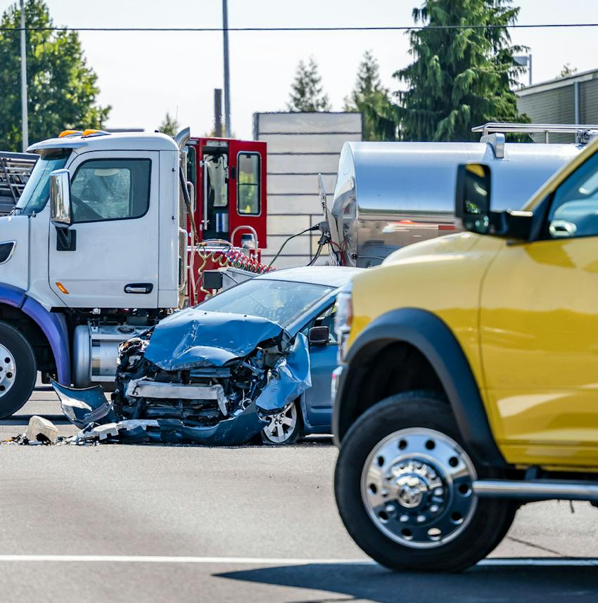 car with its front end smashed next to a gas truck