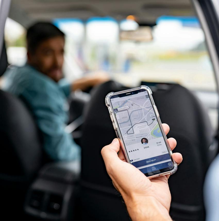 person in a car looking at their smartphone