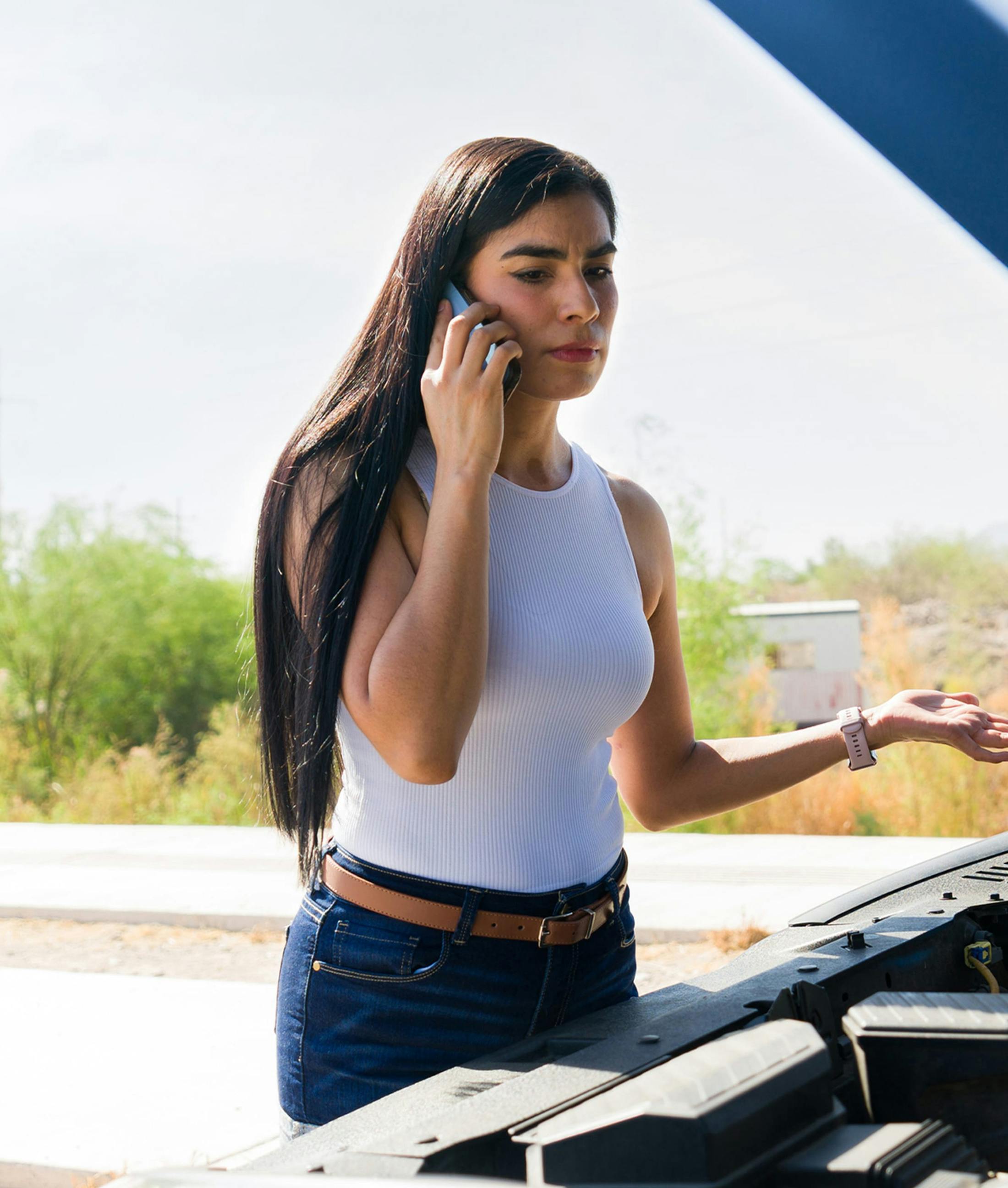 man on the phone leaning against a car