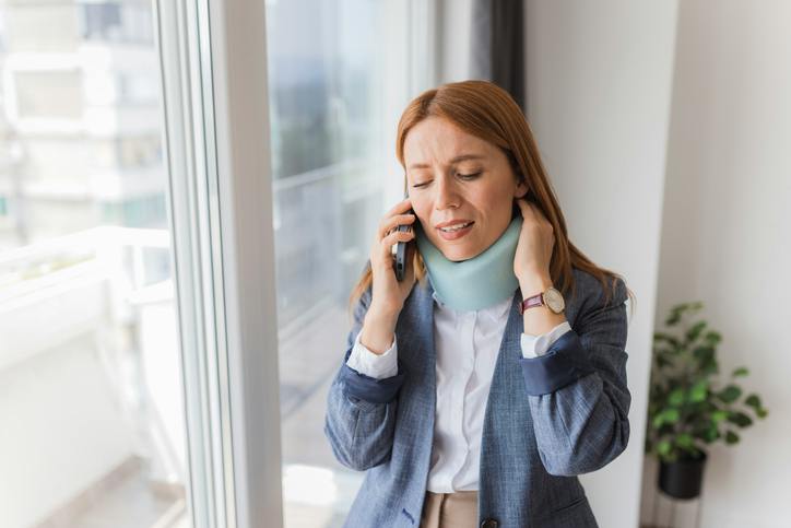 Woman on the phone wearing a neck collar